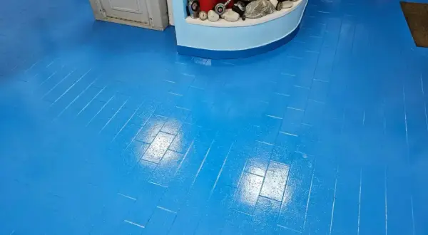Pavimento blu brillante, effetto parquet, appena finito di lavorare la resina. Riflessi luminosi sulla superficie liscia.