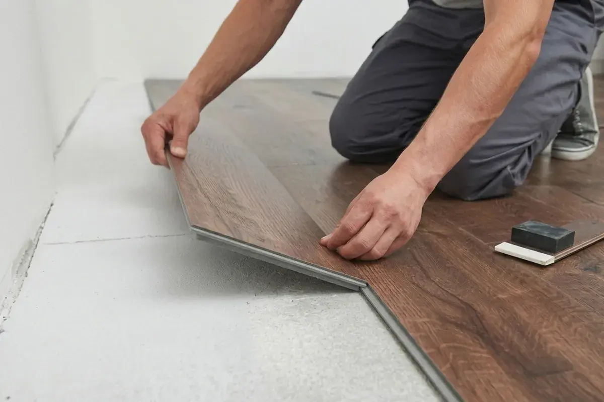 Un operaio in posa spc. di un nuovo pavimento in laminato effetto legno.