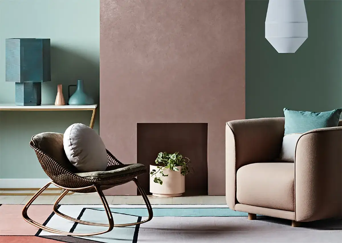 Living room with a rocking chair, armchair, and fireplace in muted colors.