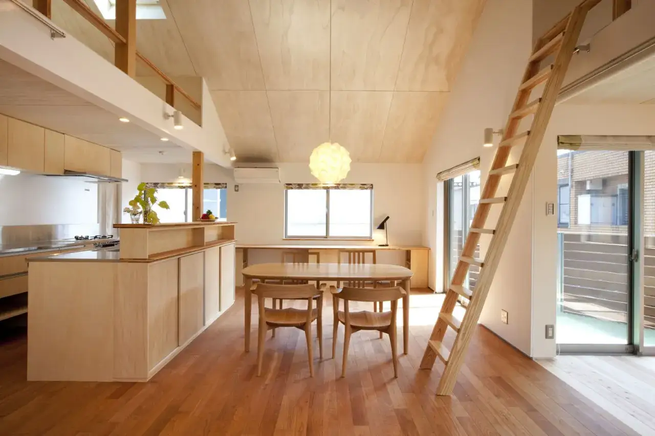 Interno moderno con cucina, sala da pranzo e scala in legno massiccio. Pavimenti e arredi in tonalit&agrave; chiare creano un'atmosfera luminosa e accogliente.
