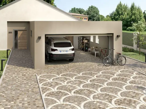 Un'auto bianca è parcheggiata in un garage aperto. Il vialetto carrabile del giardino è pavimentato con piastrelle decorative a ventaglio.