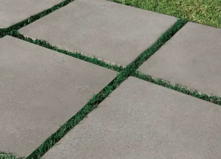 Percorso moderno con piastrelle da esterno 2 cm grigie, alternate a strisce di erba verde.